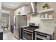 Close-up of a kitchen featuring stainless steel appliances, floating shelves and modern cabinetry at 8417 Hirsch Dr, Charlotte, NC 28277