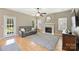 Bright living room featuring hardwood floors, a ceiling fan, and a charming fireplace at 8417 Hirsch Dr, Charlotte, NC 28277