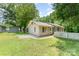 Spacious backyard with a white picket fence and lush green grass and trees at 909 Lakeview St, Kannapolis, NC 28083