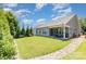 Large backyard with green grass, surrounded by trees, and a patio with outdoor seating at 101 Daybreak Ln, Belmont, NC 28012
