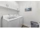 Clean laundry room with white washer and dryer, white cabinets, and decorates a small painting at 101 Daybreak Ln, Belmont, NC 28012