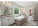 Bright bathroom features an island tub with granite countertops and bright windows at 10437 Paper Birch Dr, Charlotte, NC 28215