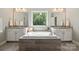 Bright bathroom features an island tub with granite countertops and bright windows at 10437 Paper Birch Dr, Charlotte, NC 28215