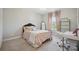 Charming bedroom with a pink bedspread, chandelier, mirror, and a dedicated workspace by the bright window at 10437 Paper Birch Dr, Charlotte, NC 28215