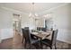 Open dining room with hardwood floors, decorative wainscoting, and a view to the living areas at 10437 Paper Birch Dr, Charlotte, NC 28215
