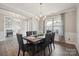 Elegant dining room with modern chandelier, a large window, and stylish gray chairs at 10437 Paper Birch Dr, Charlotte, NC 28215