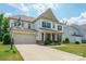 Charming two-story home with a well-manicured lawn and a basketball hoop over the garage at 10437 Paper Birch Dr, Charlotte, NC 28215