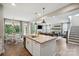 Kitchen island with bar seating opens to living and dining areas, creating a spacious living area at 10437 Paper Birch Dr, Charlotte, NC 28215