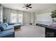 Inviting living room with a large screen, comfortable blue sectional, and modern ceiling fan for a relaxing ambiance at 10437 Paper Birch Dr, Charlotte, NC 28215