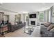 Open-concept living room with a fireplace, large windows and two sofas at 10437 Paper Birch Dr, Charlotte, NC 28215