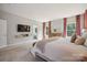 Spacious primary bedroom features a television, large windows and carpet flooring at 10437 Paper Birch Dr, Charlotte, NC 28215