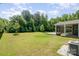 A large grassy backyard abuts a screened in back porch with a nearby HVAC unit at 12140 Mcdowell Pl, Huntersville, NC 28078