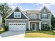 Charming two-story home showcasing a well-manicured lawn and a two-car garage at 12140 Mcdowell Pl, Huntersville, NC 28078