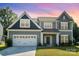 Charming two-story home with a large front yard and attached two car garage at sunset at 12140 Mcdowell Pl, Huntersville, NC 28078