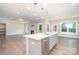 Bright, open-concept kitchen featuring a central island, modern fixtures, and stainless steel appliances at 12140 Mcdowell Pl, Huntersville, NC 28078