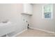 Convenient laundry room with sink, storage cabinets, and washer/dryer hookups at 12140 Mcdowell Pl, Huntersville, NC 28078