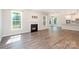 Cozy living room features a fireplace, hardwood floors, and an open layout to the kitchen at 12140 Mcdowell Pl, Huntersville, NC 28078