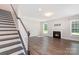 Bright living room boasts hardwood floors, a cozy fireplace, and staircase access at 12140 Mcdowell Pl, Huntersville, NC 28078