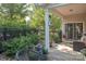 Covered back patio with outdoor seating, lush landscaping, and a tranquil view of the backyard at 1304 Hammond Dr, Matthews, NC 28104