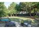 Lush backyard featuring a well-maintained lawn, mature trees, and outdoor seating area at 1304 Hammond Dr, Matthews, NC 28104