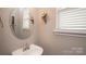 Stylish half bathroom featuring modern faucet, mirror, blinds, and wall decorations at 1304 Hammond Dr, Matthews, NC 28104