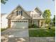 Charming two-story home with a two-car garage, stone accents, and landscaped front yard at 1304 Hammond Dr, Matthews, NC 28104