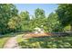 Fun community playground with swings, slides, and climbing structures, nestled in a wooded area at 1304 Hammond Dr, Matthews, NC 28104