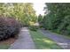 Scenic sidewalk with decorative shrubs and landscaping leads to a bridge in the community at 1304 Hammond Dr, Matthews, NC 28104