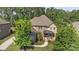 Stunning aerial view of a brick home featuring a well-manicured lawn and mature trees at 16522 Flintrock Falls Ln, Charlotte, NC 28278