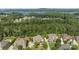 Stunning aerial view showcases the home, its manicured yard, and wooded surroundings with lake view at 16522 Flintrock Falls Ln, Charlotte, NC 28278