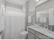 Bright bathroom featuring a shower-tub combination, white tile, and marble countertop sink at 16522 Flintrock Falls Ln, Charlotte, NC 28278