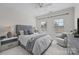 Cozy bedroom with large windows, a plush bed, and a comfortable sitting area at 16522 Flintrock Falls Ln, Charlotte, NC 28278