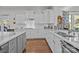 The kitchen has white cabinets, marble countertops, stainless steel appliances, and hardwood floors at 16522 Flintrock Falls Ln, Charlotte, NC 28278
