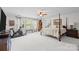 Open main bedroom featuring a four poster bed, workout area, sitting area, and bright windows at 16522 Flintrock Falls Ln, Charlotte, NC 28278