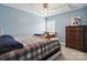 Bedroom with blue walls, a plaid bedspread, and a wooden dresser, creating a cozy space at 17711 North Shore Cir, Cornelius, NC 28031