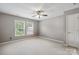 Bright bedroom with neutral walls, carpet floors, ceiling fan, and double windows overlooking greenery at 17711 North Shore Cir, Cornelius, NC 28031