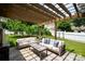 Outdoor patio under a pergola with comfortable seating and a lush green lawn at 17711 North Shore Cir, Cornelius, NC 28031