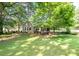 Well-maintained backyard with lush green grass, mature trees providing shade, and a patio area for outdoor enjoyment at 18439 Victoria Bay Dr, Cornelius, NC 28031