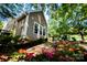 Landscaped view of home's exterior, showing a patio with a grill and flowerbeds at 18439 Victoria Bay Dr, Cornelius, NC 28031