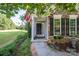 Charming front entrance with stone accents, American flag, and beautifully landscaped yard at 18439 Victoria Bay Dr, Cornelius, NC 28031