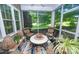 Screened porch with seating, rug, and view of the lush, green backyard at 18439 Victoria Bay Dr, Cornelius, NC 28031