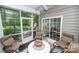 Enclosed porch showcasing neutral furniture, rug, view to backyard with a sliding door at 18439 Victoria Bay Dr, Cornelius, NC 28031