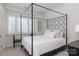 This bedroom features a black metal canopy bed with a white comforter and decorative pillows at 18534 Carnegie Overlook Blvd # 110, Davidson, NC 28036