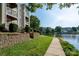 Beautiful condo building overlooking a serene lake with a landscaped pathway and mature trees at 18730 Nautical Dr # 102, Cornelius, NC 28031