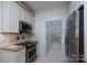 Well-lit kitchen featuring granite countertops, stainless steel appliances, and tiled floors at 18730 Nautical Dr # 102, Cornelius, NC 28031