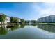 Picturesque pond view showcasing surrounding condos and a fountain against a clear sky, reflecting community charm at 18730 Nautical Dr # 102, Cornelius, NC 28031