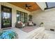 Cozy covered back porch with ceiling fan, brick surround, and outdoor seating arrangement at 19 Berea Baptist Church Rd, Stanfield, NC 28163