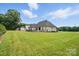 Large, grassy backyard featuring a light brick house with a dark roof and a black fence at 19 Berea Baptist Church Rd, Stanfield, NC 28163