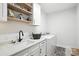 Laundry room with washer and dryer, countertop, sink, shaker cabinets, and open shelving at 19 Berea Baptist Church Rd, Stanfield, NC 28163