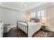 Cozy bedroom with an iron bed frame, dark wood floors, and natural light at 2015 Lombardy Cir, Charlotte, NC 28203